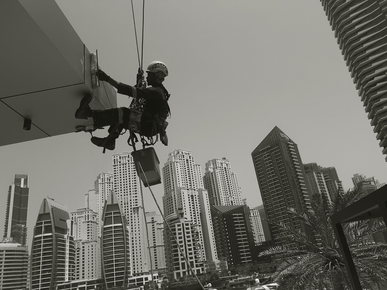 Arabian Height technician cleaning a high-rise window above Dubai Marina